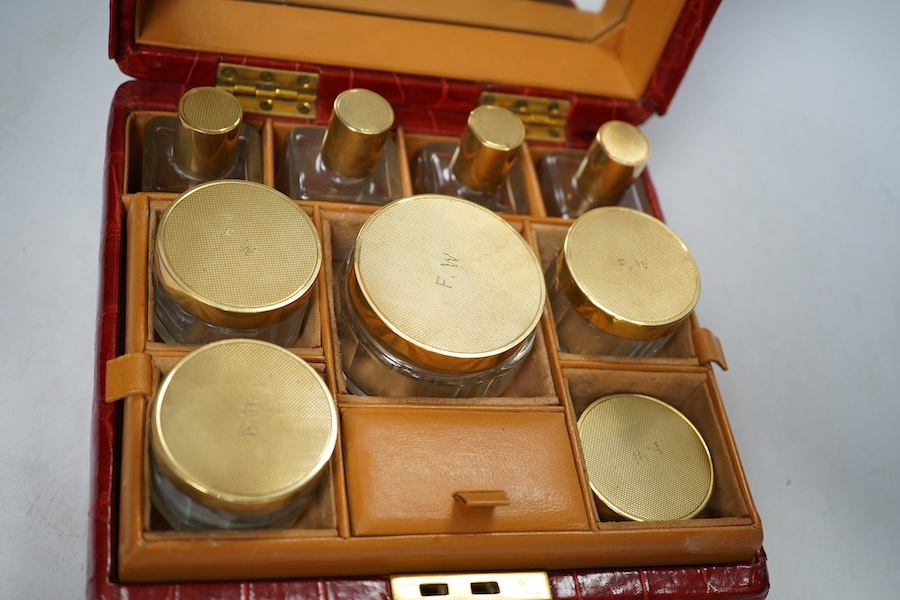 An early 20th century crocodile skin vanity case with glass jars, 21.5cm wide. Condition - fair, no key